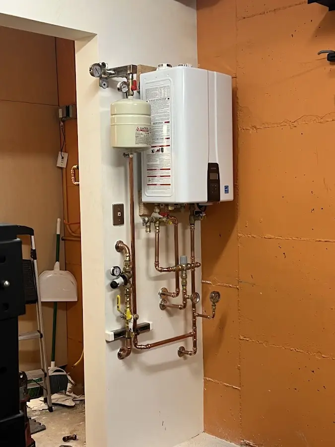 Plumbing technician inspecting water heater connections in Bonham